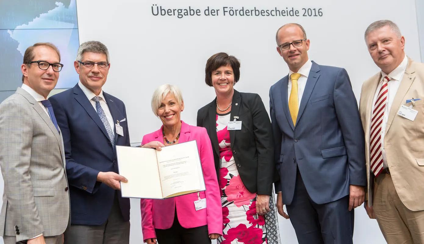 Bundes-Infrastrukturminister Dobrindt (links) überreicht an den Vogelsberg-Landrat und bigo-Geschäftsführer Görig (Zweiter von links) den Förderbescheid fürs schnelle Internet in Gewerbegebieten. Mit auf dem Foto von links die Bundestagsabgeordneten Müller, Kömpel, Brand und Veith. Foto: Hans-Peter König, BMVI